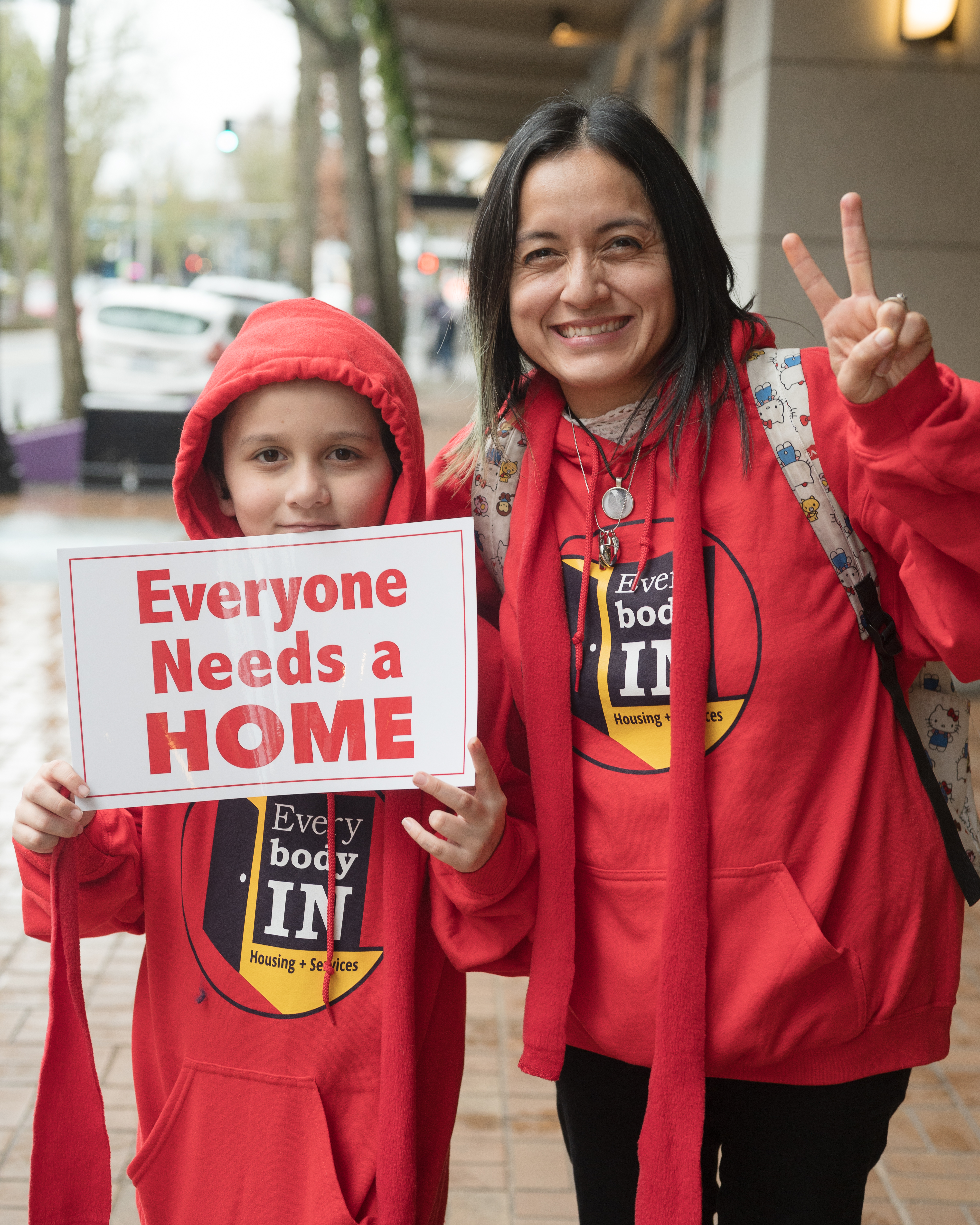 A person and a child holding a sign

Description automatically generated