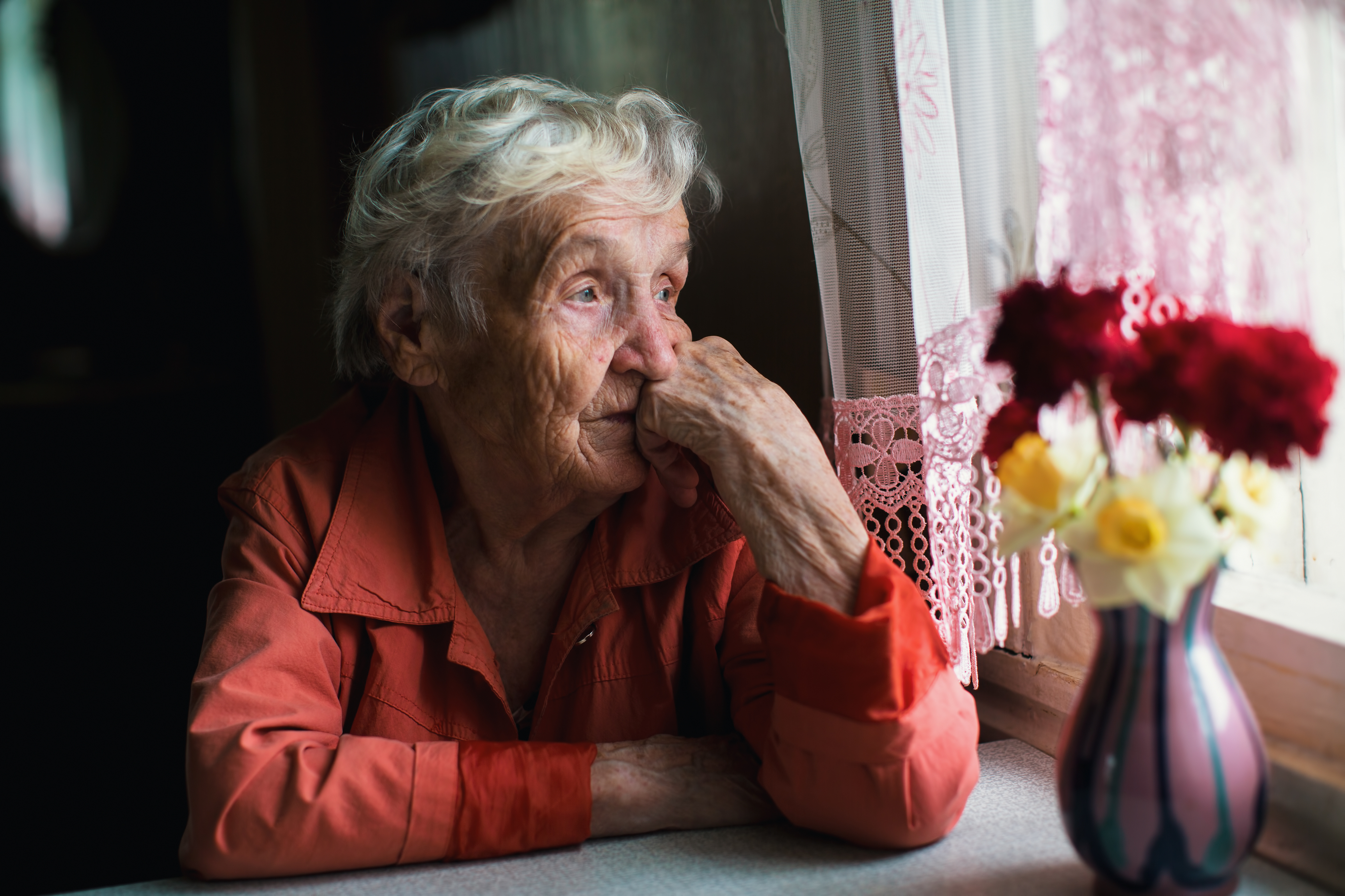 An older woman looking out a window