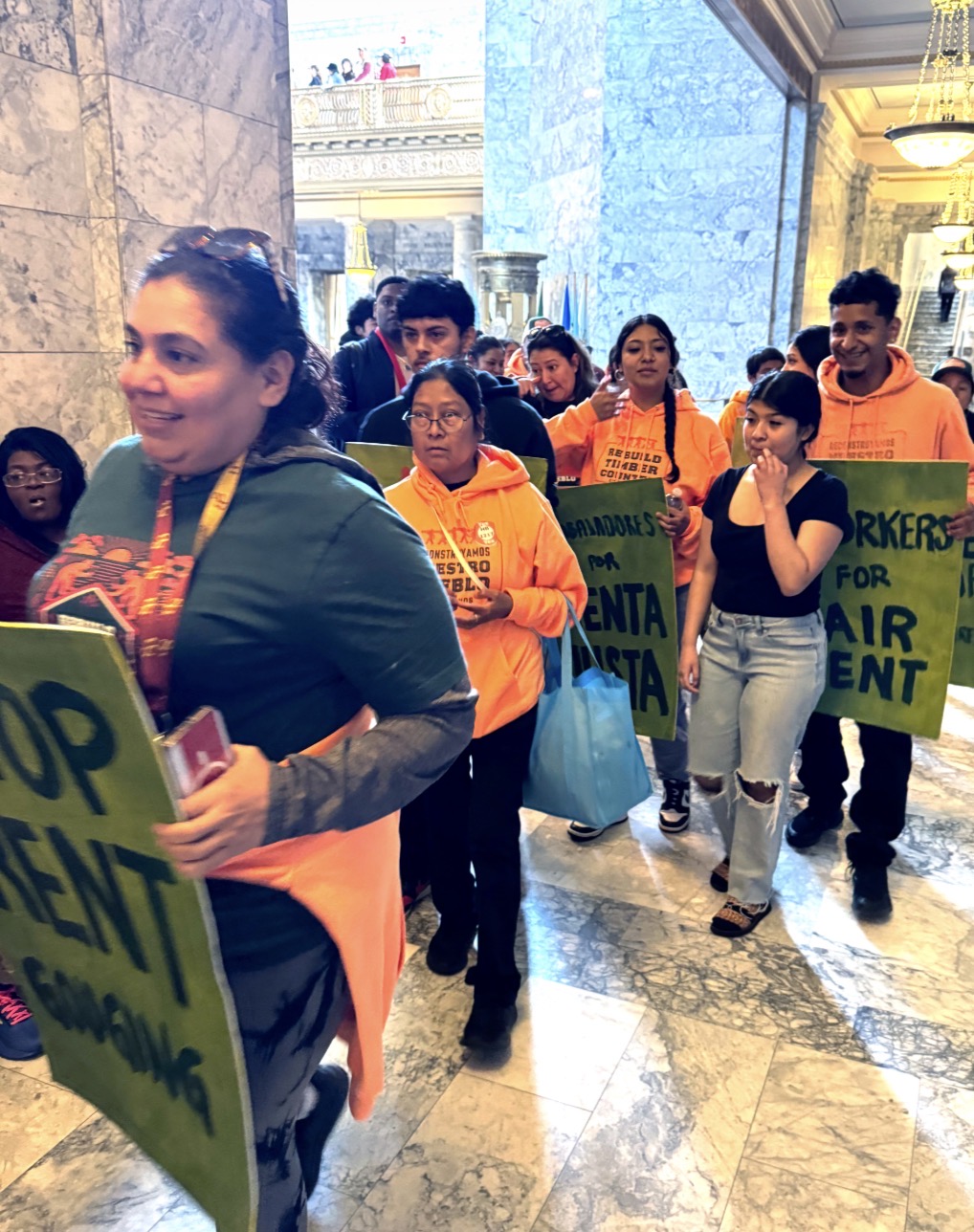 Advocates march through the state Capitol to demand lawmakers reduce the proposed cap on annual rent increases.