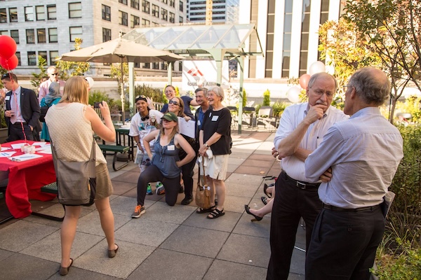 Undoubtedly strategizing about something important at an event, while members of the Resident Action Project pose in the background.